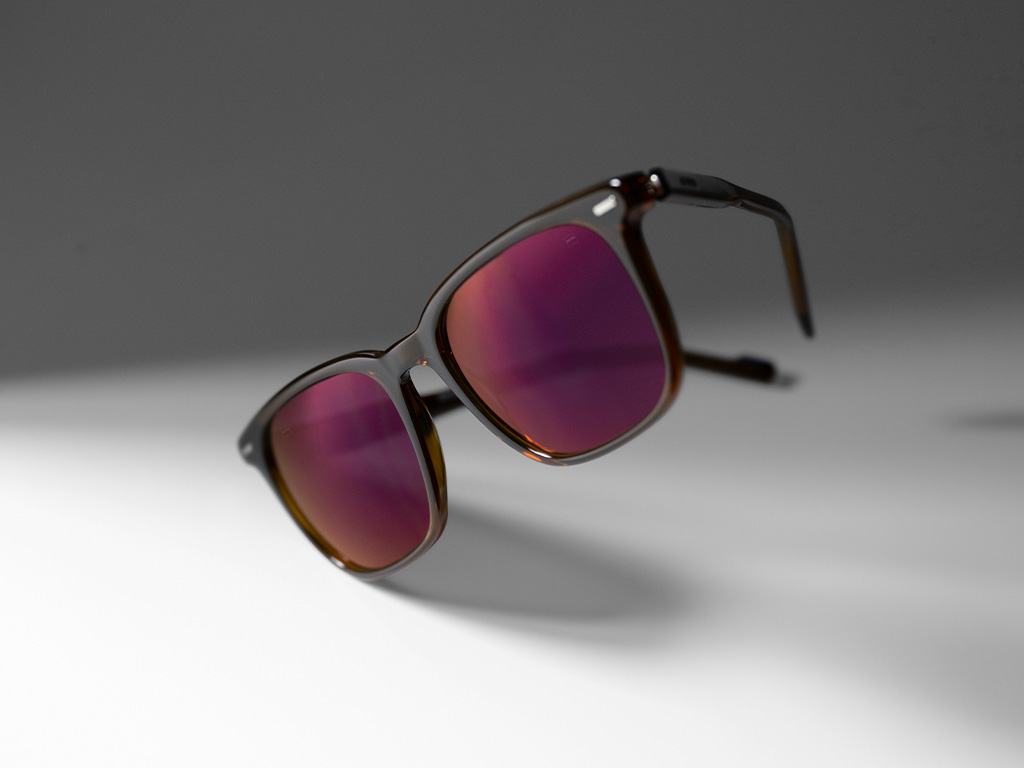 Image of a ZEISS prescription sunglass lens with Burgundy tinted lenses and ZEISS DuraVision Gold lens coating.