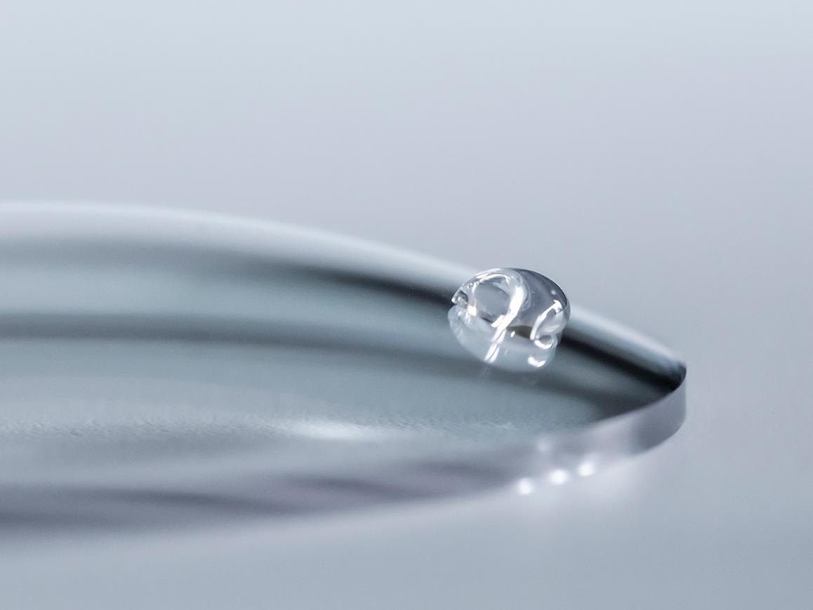 A water drop slides off a ZEISS lens with an easy clean coating.