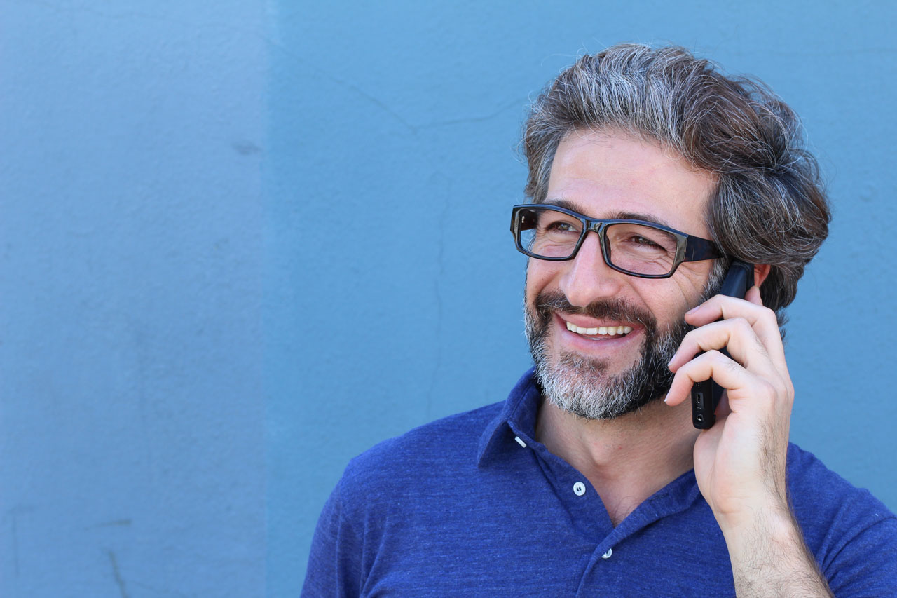 A man with glasses talking on mobile phone