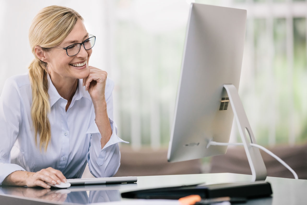 Woman looking at computer screen with glasses on